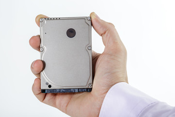 Man's hand holds a 2.5 inch hard drive. View of the upper part of the HDD. Isolated on white background.
