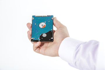 Man's hand holds a 2.5 inch hard drive. View of the backside HDD, from the PCB. Isolated on white background.