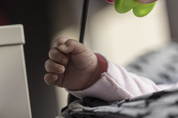 Tiny baby closed fist hand isolated on a toy playground