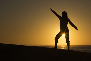 Fototapeta premium Silhouette of female form with sun star on beach in Mexico