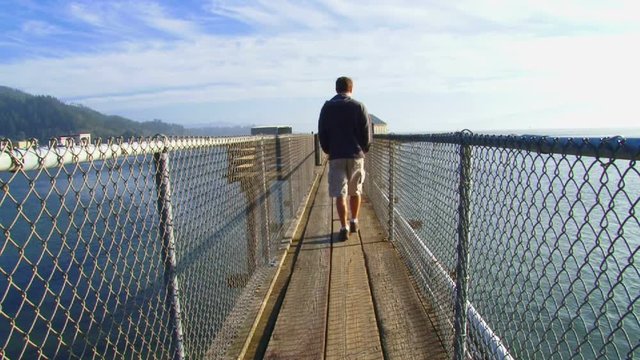 Layered Clip with 3 shots of man walking away towards Pacific Ocean in Oregon on solo journey.