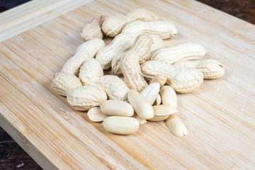 dried fruit, nuts, hazelnuts and almonds on cutting board and antique table