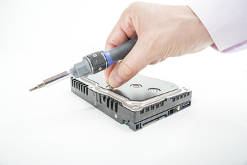 Hand repairman unscrews the 3.5 inch hard drive cover with a screwdriver. Isolated on white background.