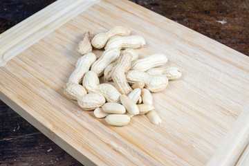dried fruit, nuts, hazelnuts and almonds on cutting board and antique table