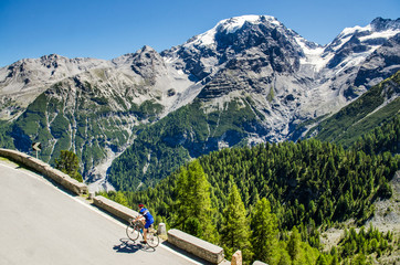 Fototapeta premium Famous Passo Dello Stelvio Road in Swiss - Italy border. Favourite place for all bike riders. Alone biker on the top.