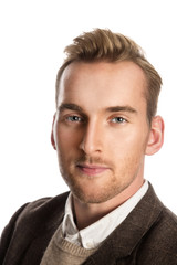 Obraz premium A attractive man in his 20s standing against a white background wearing a brown suit with a sweater and white shirt.