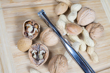 dried fruit, nuts, hazelnuts and almonds on cutting board and antique table