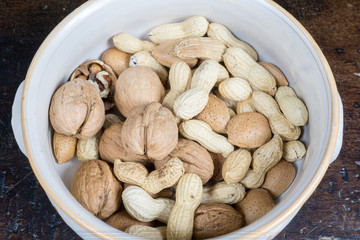 dried fruit, nuts, hazelnuts and almonds on cutting board and antique table