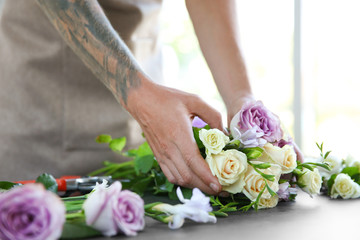 Male florist making bouquet at flower shop