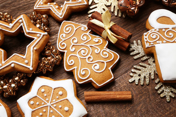 Tasty gingerbread cookies and Christmas decor on wooden background, close up