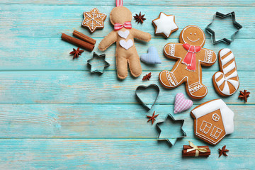Delicious Christmas cookies with cutters on wooden background