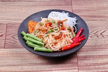 Spicy and sour mixed vegetable salad with rice noodle served .
