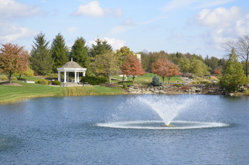 Beautiful Wedding Gazebo in the park with fountains in the pond on a sunny summer day