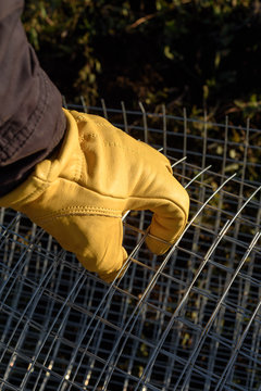 Male Yellow Gloved Hand Handling Chicken Wire