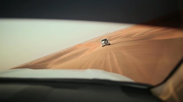 Desert Safari SUVs bashing through the arabian sand dunes. View from the car 5.