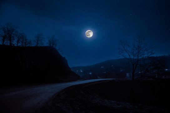 Full moon over road at night