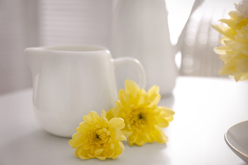 Yellow chrysanthemum at milk jug on table
