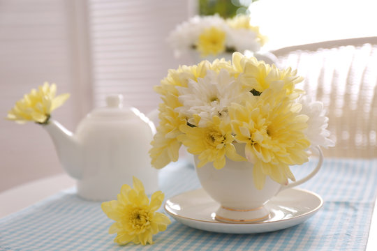 Flower bouquet of chrysanthemum in cup on blue napkin