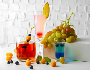 Delicious cocktails with berries on white table
