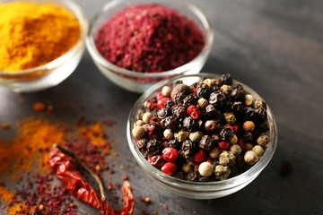 Aromatic spices in glass bowls on grey background