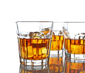 Glasses of whisky with ice isolated on white