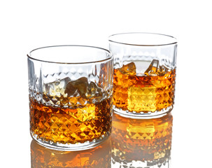 Glasses of whisky with ice isolated on white