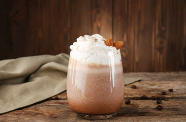 Fresh milkshake with almond on wooden background