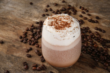 Fresh milkshake with coffee beans on wooden background