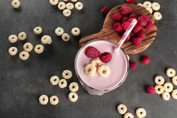 Fresh milkshake with raspberry on grey textured background