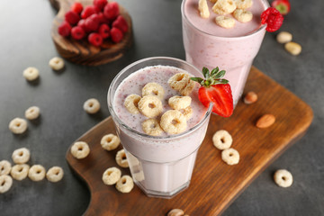 Fresh milkshake with strawberry on wooden cutting board closeup