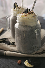 Delicious milk dessert with sweets in glass jug on table, closeup