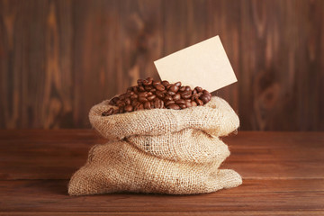 Purse with roasted coffee beans on wooden background