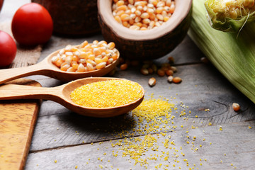 Composition of corn seeds and groats on wooden table