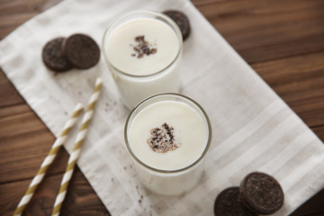 Tasty milk shake with cookies on table