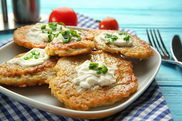 Plate with tasty potato pancakes for Hanukkah on wooden table, closeup