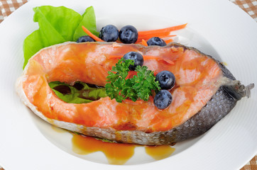 salmon steak with vegetables and fruit.