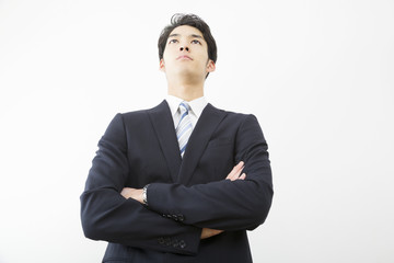 男性　ビジネスマン　腕組み　見上げる　見つめる　気合い　やる気　真剣　ローアングル　白バック