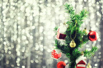Fototapeta na wymiar Christmas balls decorated in tree on bokeh background