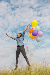 Beautiful Girl jumping with balloons on the beach