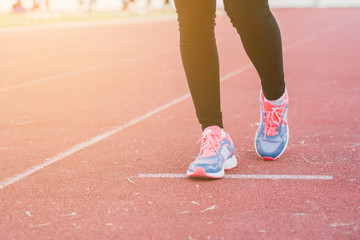 Young lady running on road closeup on shoe., at time sunset