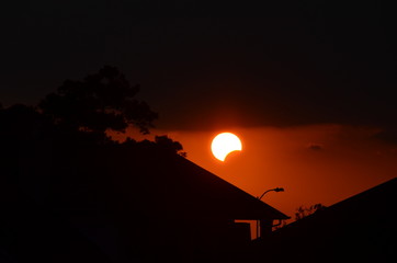 Solar eclipse over house and neighborhood