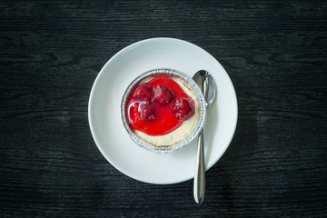 Strawberry Cheese pie on black wooden background