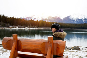 Young female traveller sitting on the bench, beautiful landscape