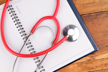 Medical concept. Stethoscope and open notebook on wooden background