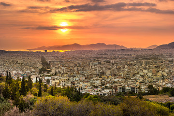 Panorama of Athens at sunset. Beautiful cityscape with seashore and distant islands visible under...
