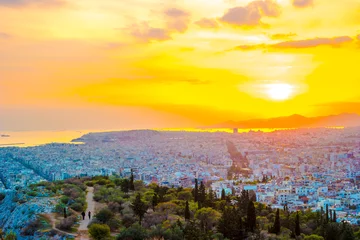 Poster Panorama of Athens at sunset. Beautiful cityscape with seashore and distant islands visible under the red sunset sky. Travel photography. © romas_ph