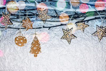 new year decorations with homemade gingerbread cookies and holiday lights on bare tree branches