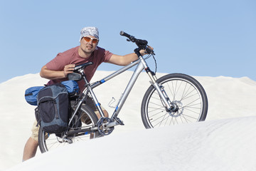 Traveling man on a bicycle in the desert.