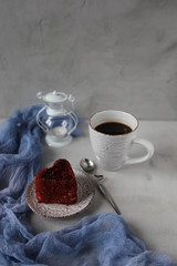 Cup of hot coffee and red velvet cake on rustic stone background. Valentine's day celebration concept. place for text