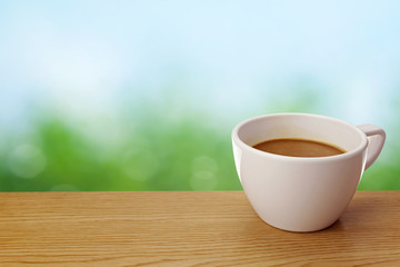 A cup of coffee on table over green background